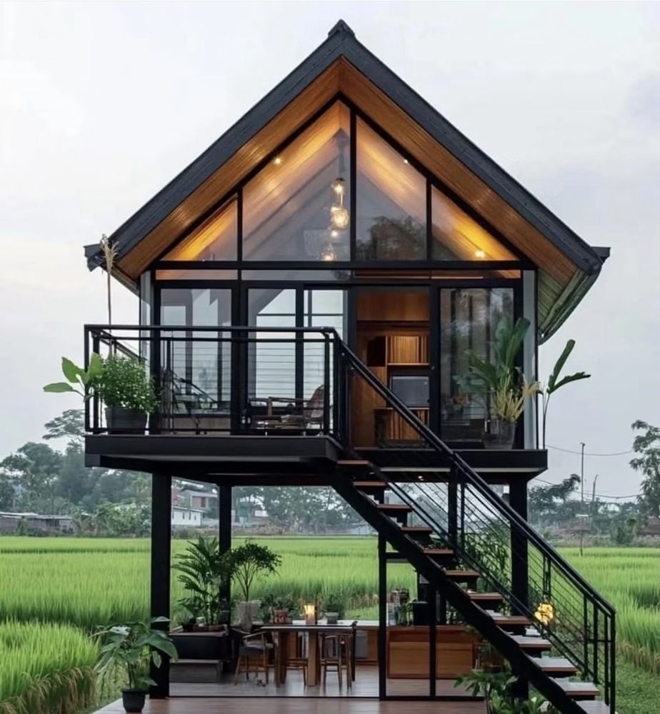 Casa elevada con techo en pico y ventanal triangular de cristal