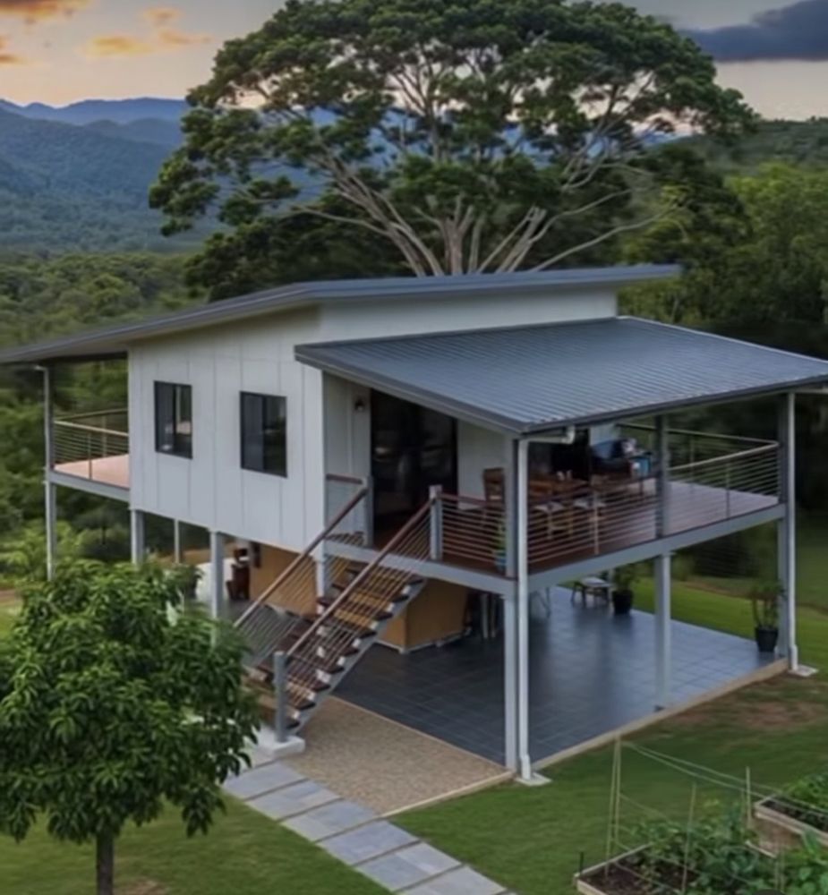 Casa blanca elevada con terraza amplia y vistas al verde